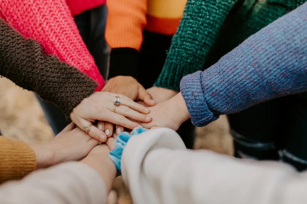 Several hands joined together in a circle.