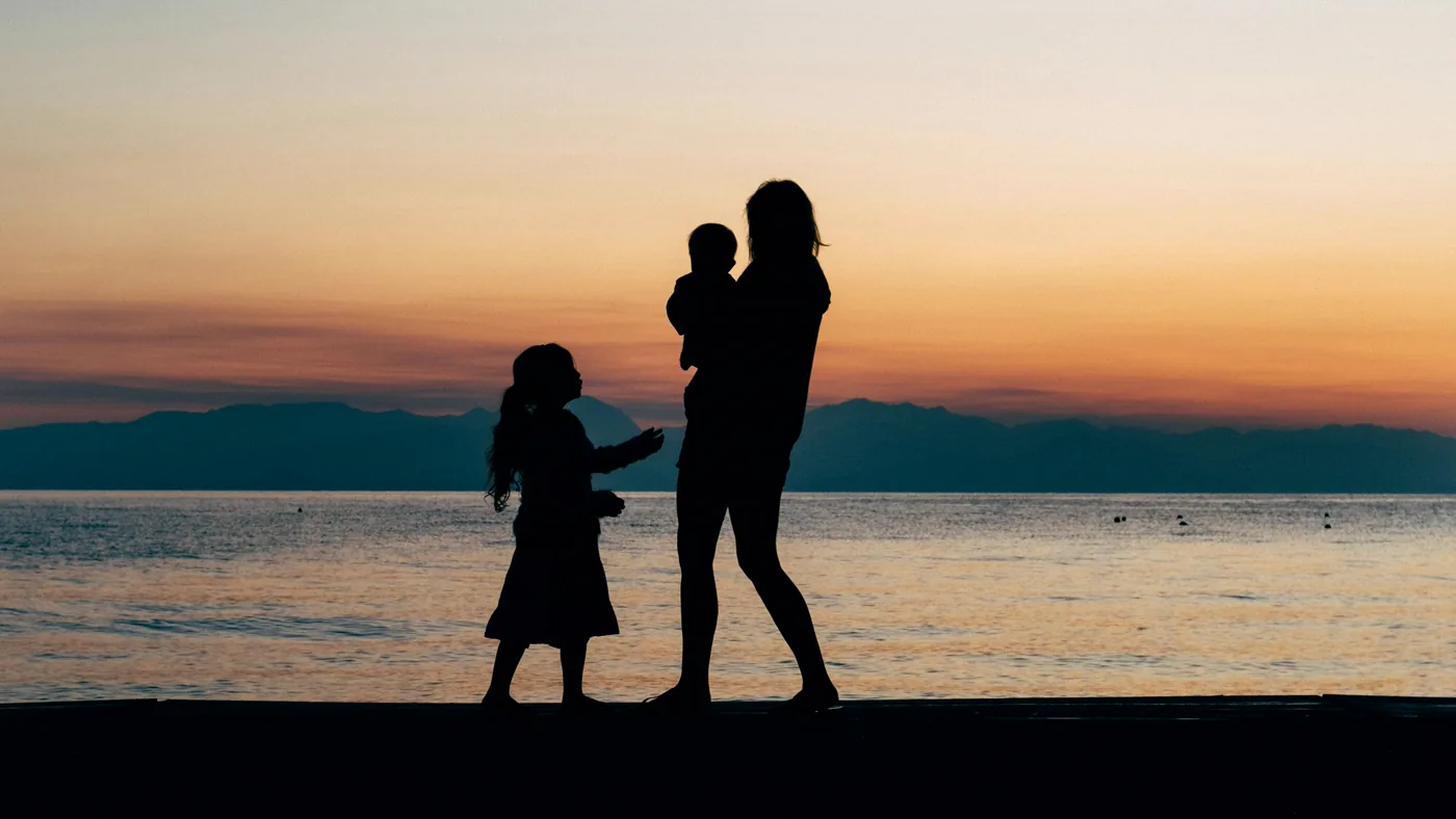 A family holding hands together at sunset.